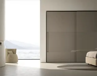 Armadio Atelier con ante scorrevoli con maniglia integrata in melaminico Fango e inserti in vetro Shine di Adok